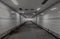 Perspective view of Ambient public underpass with white tiled walls and stripes of ceiling neon lights