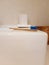 Perspective view of bamboo toothbrush and empty ceramic toothbrush holder on white sink and other accessories in bathroom. Vintage