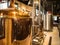 Perspective view of beer brewery with multiple tubes, pipes and large stainless steel tank recipient