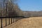 Perspective view of black fencing by a mowed field, winter