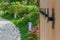 Perspective view through blurred open wooden gate with metal rivets decor to stone walkway in Japanese Zen garden