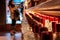 Perspective view of a bokeh of a woman shopping for wine or other alcohol in a liquor store standing in front of shelves full of