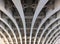 Perspective view of curved arch shaped steel girders under an old road bridge with rivets and struts painted grey