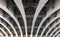 Perspective view of curved arch shaped steel girders under an old road bridge with rivets and struts painted grey