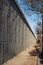 Perspective view of dirt and debris on narrow walkway area beside wall of an elevated highway