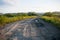 Perspective view of a ground country road and fields and the woo