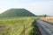 Perspective view of a local asphalt street in Kumamoto Prefecture, Japan, that have Aso Mountains and green natural meadows