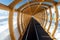 Perspective view of magic carpet transportation ski lift conveyor belt covered with wooden arch roof tunnel at alpine mountain
