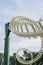 A Perspective view of two inverted loops of a roller coaster against a blue and cloudy sky