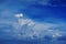Perspective wide view of romantic navy blue sky with white grey clouds. High resolution artistic skyline background image
