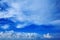 Perspective wide view of romantic navy blue sky with white grey clouds. High resolution artistic skyline background image