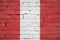 Peru flag is painted onto an old brick wall