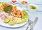 Peruvian food: fish ceviche and chicharron de pescado with fried cassava, sweet corn and sweet potato, served on a white plate