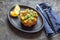 PERUVIAN NIKKEI FOOD. Salmon avocado ceviche on black plate, black background top view