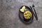 PERUVIAN NIKKEI FOOD. Salmon avocado ceviche on black plate, black background top view