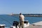 Pesaro, Italy: an old fisherman in fishing on the pier of the harbor