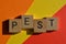 Pest, business acronym in 3D wooden alphabet letters isolated on colourful background