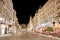 Pestsaule between illuminated buildings during night at Graben street in Vienna, Austria