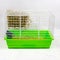 Pet cage with green pallet of shavings, sawdust, feed, hay and hay. Keeping pets in cages. Side view.