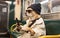 Pet dog rides in a subway car using a mobile phone, sitting on a seat in sunglasses and a hat. Generative AI