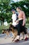 Pet Love, Dog Training, best dog breeds for family. Young sports couples walking with two German Shepherd dogs outdoors