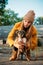 Pet Love. Volunteer woman plays with homeless puppies in the autumn park. Authentic moments of joy girl playing with