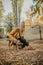 Pet Love. Young happy woman plays with puppies in the autumn park. Authentic moments of joy girl playing with stray dogs