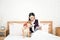 Pet Lover. Shiba Inu dog and Asian woman in the bedroom. The girl and the dog are watching the tablet on the bed