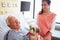 Pet Therapy Dog Visiting Senior Male Patient In Hospital