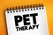 Pet therapy - guided interaction between a person and a trained animal, text concept on notepad