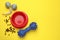 Pet toys, food and bowl on yellow background, flat lay. Space for text