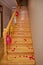 Petals of a red rose on a wooden staircase . Red, yellow, white balloons hanging on the handles of the stairs . Wooden staircase