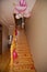 Petals of a red rose on a wooden staircase . Red, yellow, white balloons hanging on the handles of the stairs . Wooden staircase