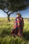 Peter Bender in Senior Elder robe of Masai standing near Acacia Tree in the Lewa Conservancy of Kenya Africa