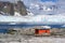 Petermann Island, beautiful Antarctic Island with penguins on rocks, abandoned station and snow covered mountains behind Ocean.