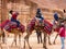 PETRA, JORDAN: Group of tourists on camels in Petra Rose City