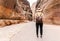 Petra, Jordan - Tourist with hat in Siq gorge in Petra historic and archaeological city in southern Jordan