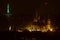 Petrin Lookout Tower in Saint Patrick Day green color with Prague castle and cathedral at night