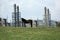 Petroleum refinery in romania, with horse on green meadow