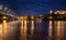 Petrovaradin fortress in Novi Sad, Serbia illuminated with colorful street lights and reflection in the Danube river and rainbow