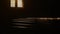 Pews and window in dark. Inside old, historic church; dark atmosphere and reflection of sun,