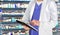 Pharmaceutical staff at drugstore with medicine in background