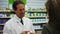 A pharmacist advising a customer on medication