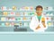 Pharmacist black man with medicine at counter in pharmacy