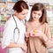 Pharmacist and customer looking at medication box