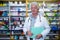 Pharmacist holding files in pharmacy