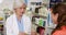 Pharmacist packing medicine in paper bag for customer