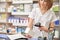 Pharmacist scanning barcode with device in drugstore.