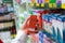 Pharmacist scanning price on a red medicine box with barcode reader in pharmacy store