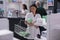 Pharmacist woman gathering pills packages, putting in basket